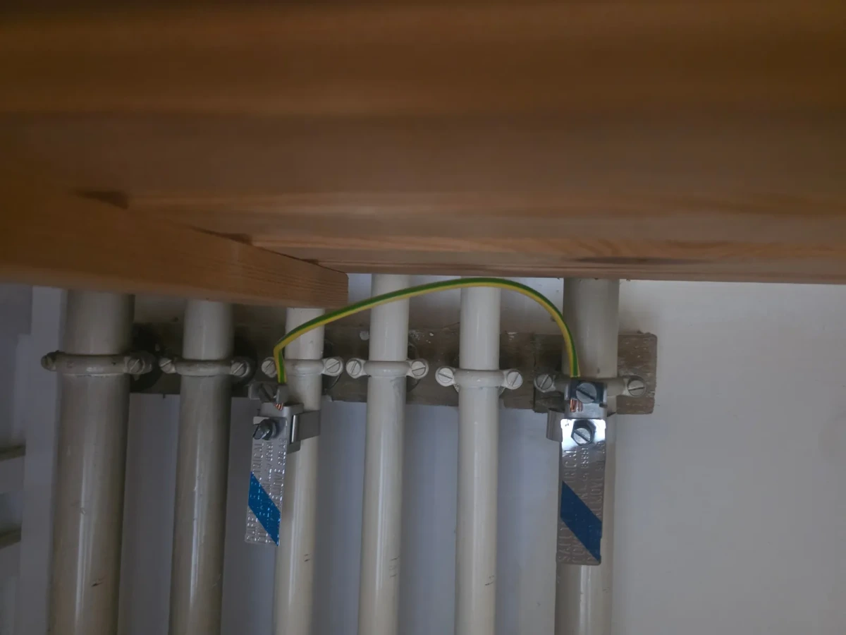Main protective bonding clamped to the pipework under the stairs